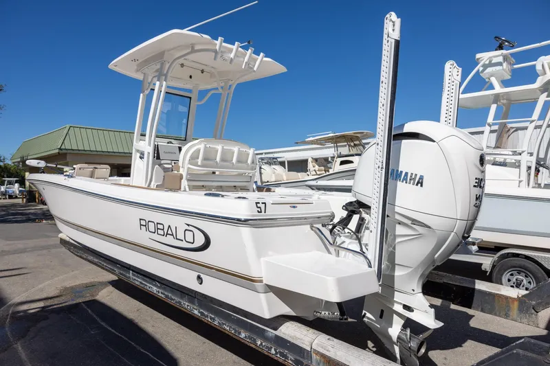 Slide: The Image of 2023 Robalo 246 Cayman boat with Yamaha engine, docked under clear blue sky. - 3
