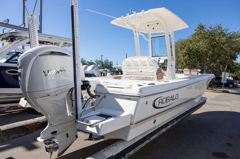 Slide: The Image of 2023 Robalo 246 Cayman boat with Yamaha engine, docked outdoors on a sunny day. - 4