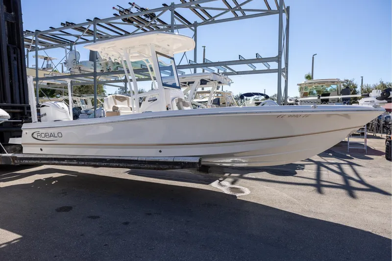 Slide: The Image of 2023 Robalo 246 Cayman boat on a trailer in a marina setting. - 5
