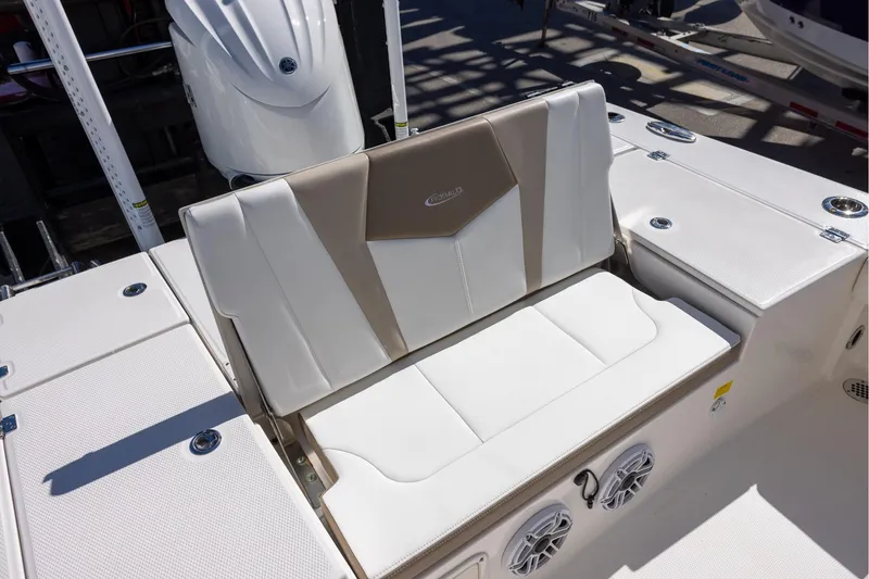 Slide: The Image of 2023 Robalo 246 Cayman boat seating area with white and beige upholstery. - 9