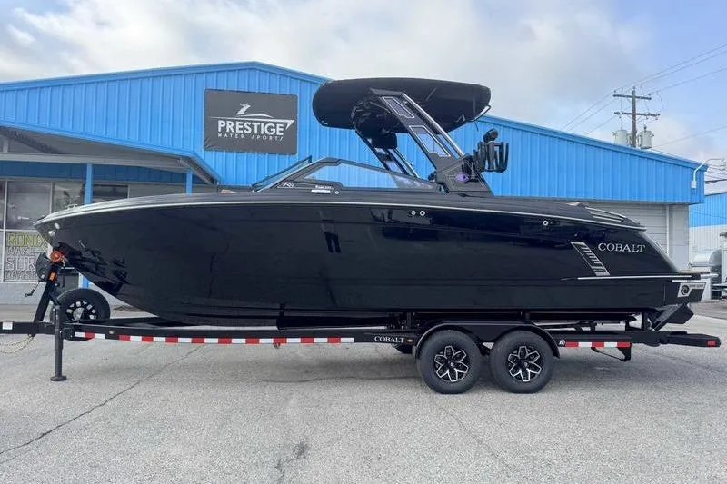The Image of 2026 Cobalt R8 Surf boat on trailer at Prestige Water Sports dealership. - 1
