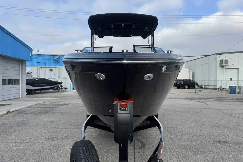 Slide: The Image of 2026 Cobalt R8 Surf boat on trailer, parked in industrial area. - 6