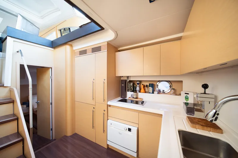 Slide: The Image of Modern kitchen interior on 2010 Beneteau Monte Carlo 47 yacht, featuring sleek cabinetry and appliances. - 39