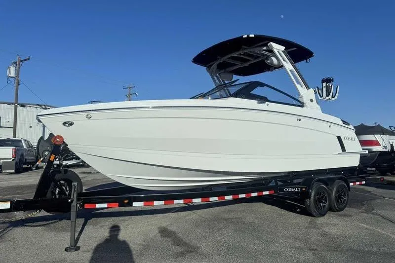 Slide: The Image of 2026 Cobalt R6 Surf boat on trailer, parked outdoors under clear blue sky. - 4