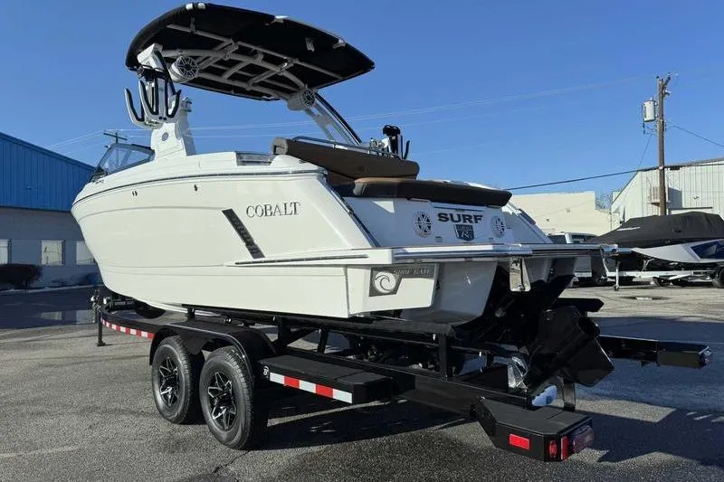 Slide: The Image of 2026 Cobalt R6 Surf boat on trailer, displayed outdoors under clear blue sky. - 7