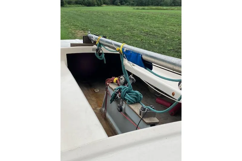 Slide: The Image of 1961 Flying Scot 19 sailboat interior with ropes and rigging, set against a grassy field. - 3