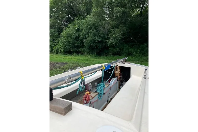 Slide: The Image of 1961 Flying Scot 19 sailboat with colorful ropes, set against lush greenery. - 4