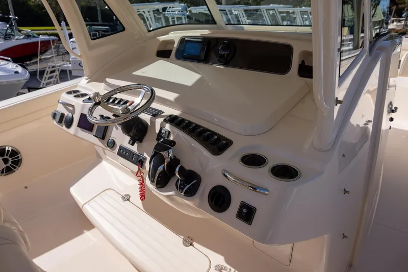 Slide: The Image of 2022 Grady-White Canyon 376 boat dashboard with steering wheel and controls. - 10