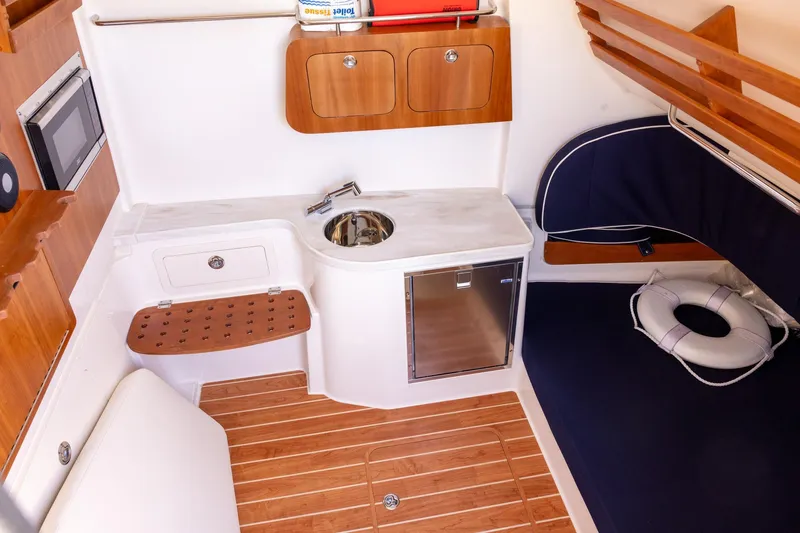 Slide: The Image of 2022 Grady-White Canyon 376 cabin interior with kitchenette and seating area. - 25