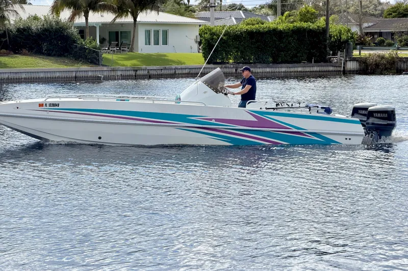 Slide: The Image of 2001 Cobra Predator 3100 speedboat with vibrant graphics cruising on a calm waterway. - 10