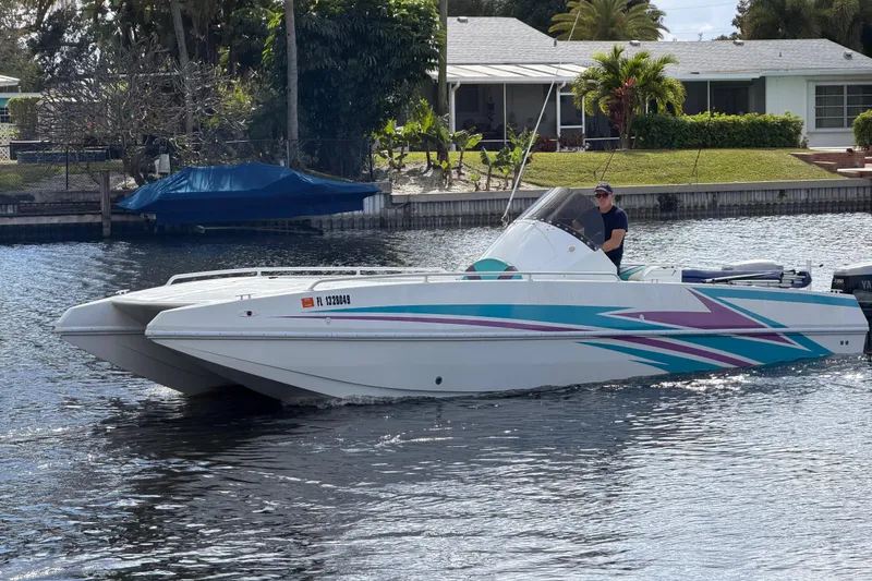 Slide: The Image of 2001 Cobra Predator 3100 boat cruising on a calm waterway near residential area. - 11