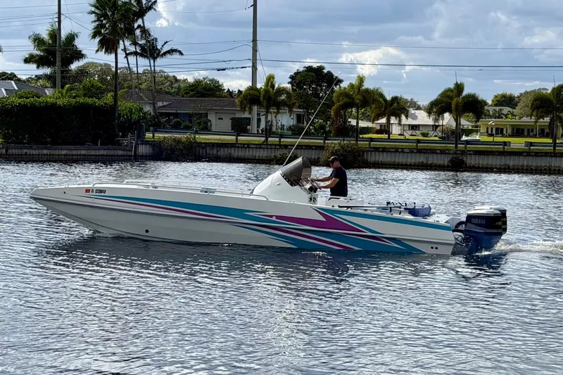 Slide: The Image of 2001 Cobra Predator 3100 speedboat cruising on a calm waterway with vibrant graphics. - 12