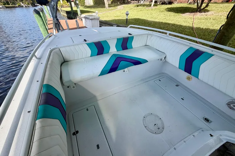 Slide: The Image of 2001 Cobra Predator 3100 boat interior with colorful seating by a dock. - 15