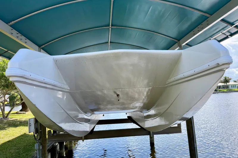 Slide: The Image of 2001 Cobra Predator 3100 boat under a blue canopy, docked by the water. - 24