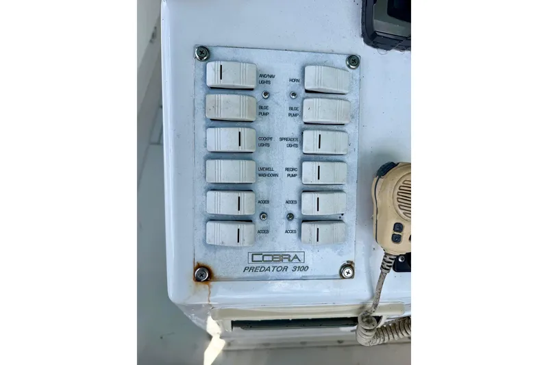 Slide: The Image of Control panel of a 2001 Cobra Predator 3100 boat with labeled switches. - 25