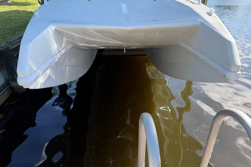 Slide: The Image of 2001 Cobra Predator 3100 catamaran docked on calm water. - 33