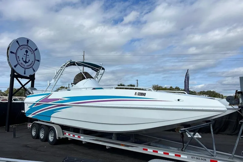 Slide: The Image of 2001 Cobra Predator 3100 boat on trailer, displayed outdoors under cloudy sky. - 6