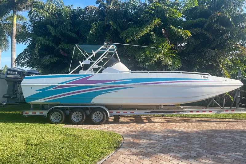 Slide: The Image of 2001 Cobra Predator 3100 boat on trailer, vibrant graphics, parked outdoors. - 7