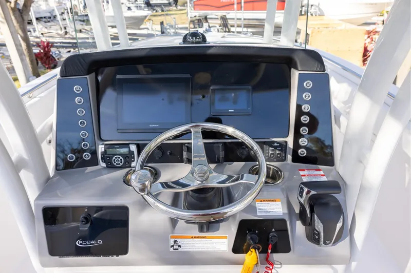 Slide: The Image of 2022 Robalo R242 Explorer boat dashboard with steering wheel and navigation controls. - 11