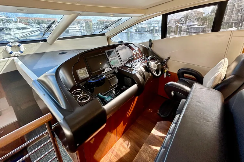 Slide: The Image of Luxurious 2010 Sunseeker Predator 64 yacht cockpit with modern navigation controls and leather seating. - 10