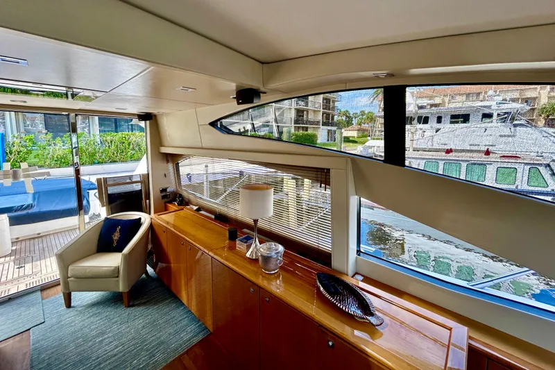 Slide: The Image of Interior of 2010 Sunseeker Predator 64 yacht, featuring elegant furnishings and marina view. - 9