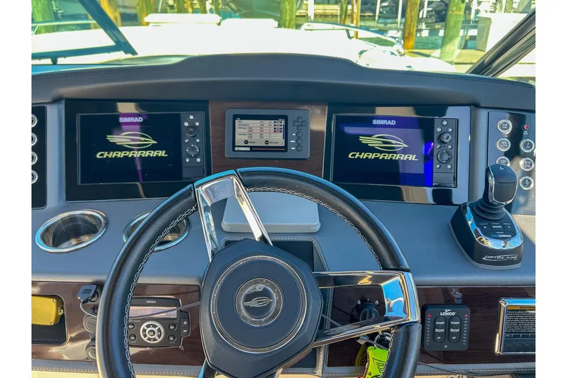 Slide: The Image of 2021 Chaparral 280 OSX boat dashboard with steering wheel and dual Simrad displays. - 10