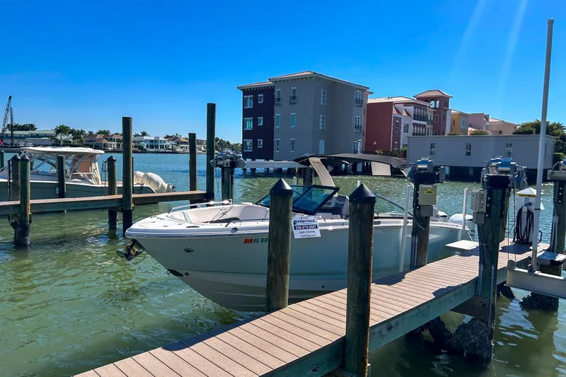 Slide: The Image of 2021 Chaparral 280 OSX docked at marina with waterfront buildings in background. - 13