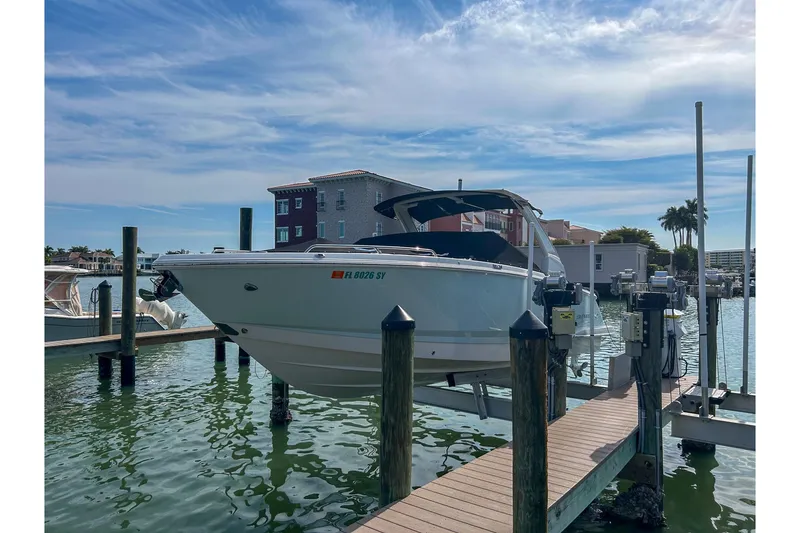 Slide: The Image of 2021 Chaparral 280 OSX boat docked at marina under clear blue sky. - 4