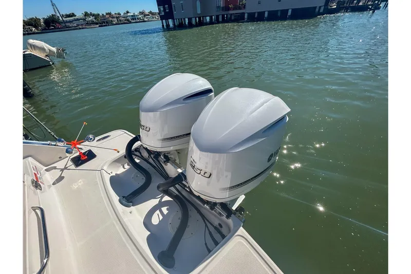 Slide: The Image of Twin outboard engines on a 2021 Chaparral 280 OSX boat, docked by the water. - 5