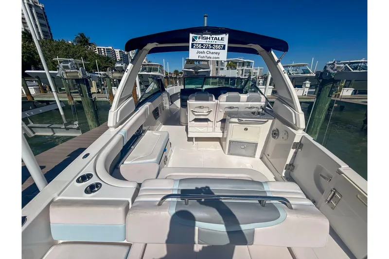 Slide: The Image of 2021 Chaparral 280 OSX boat interior at dock, featuring seating and amenities. - 6