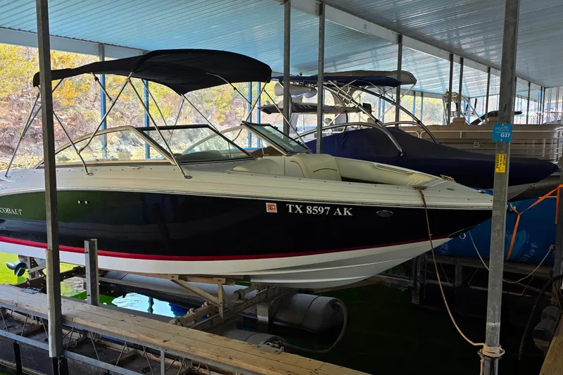 The Image of 2007 Cobalt 212 boat docked in a covered marina, featuring sleek design and black hull. - 1