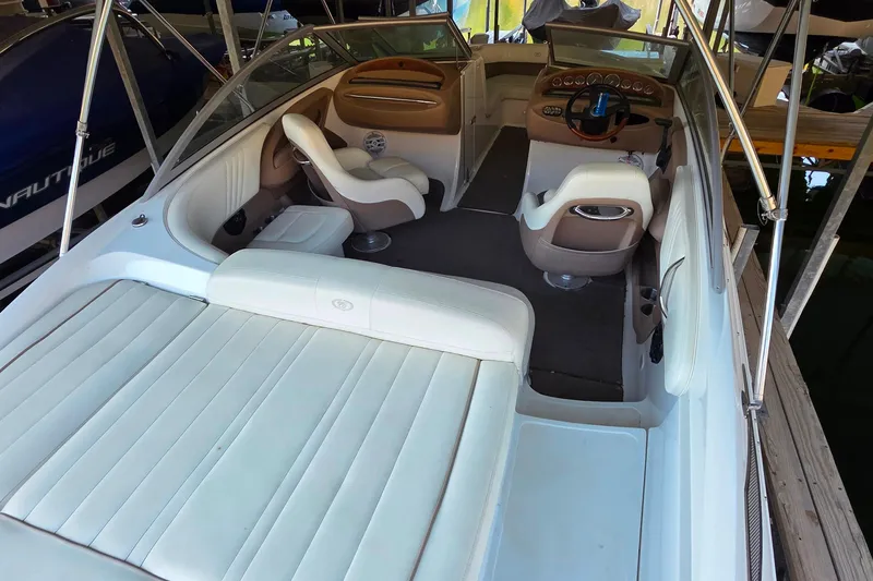 Slide: The Image of 2007 Cobalt 212 boat interior with white and beige seating, steering wheel, and dashboard. - 11