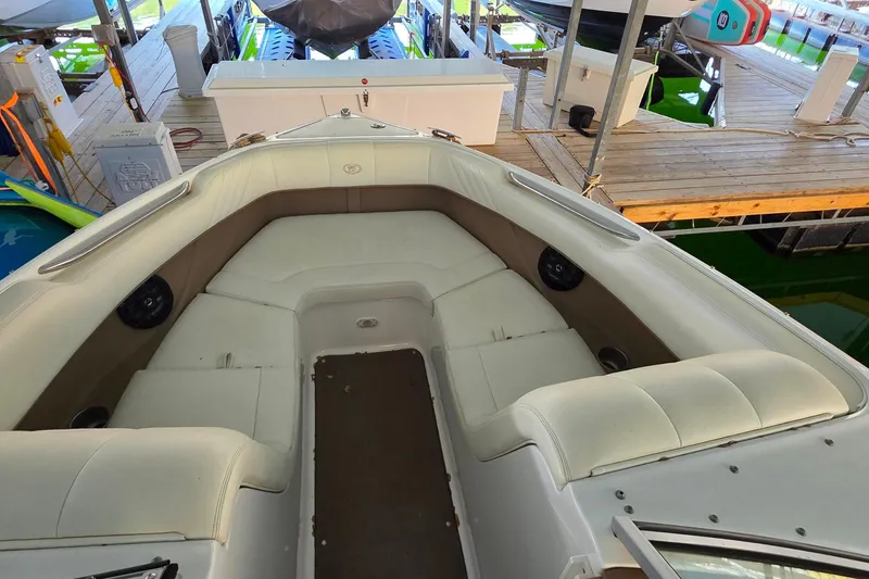 Slide: The Image of 2007 Cobalt 212 boat interior with white seating, docked in a marina. - 30