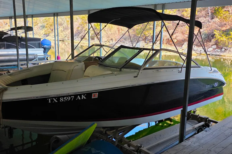 Slide: The Image of 2007 Cobalt 212 boat docked under a covered marina, featuring sleek black and white design. - 5