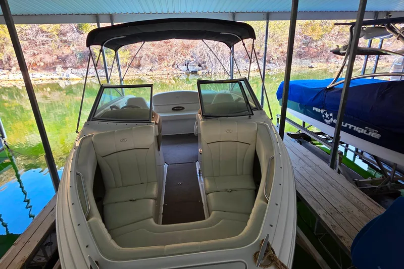 Slide: The Image of 2007 Cobalt 212 boat docked, featuring spacious seating and canopy, surrounded by calm water. - 7