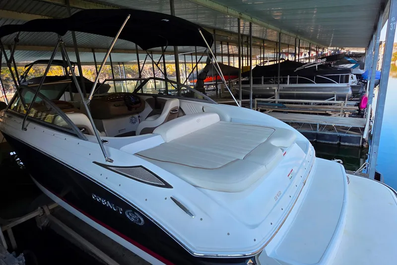 Slide: The Image of 2007 Cobalt 212 boat docked in a covered marina, featuring sleek design and spacious seating. - 8
