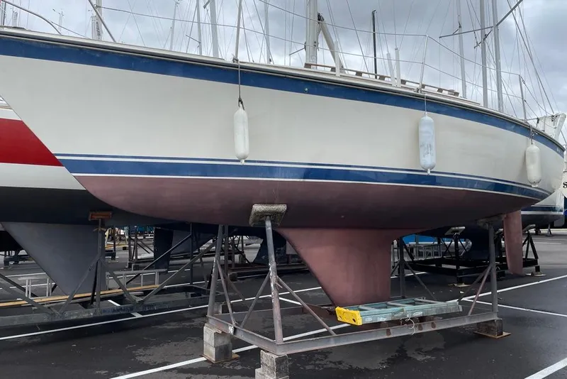 Slide: The Image of 1982 O'Day 28 sailboat on stands in a marina, with blue and white hull. - 12