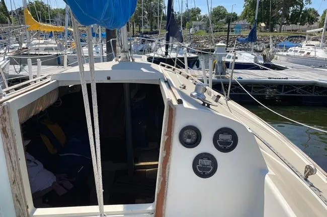 Slide: The Image of 1982 O'Day 28 sailboat docked at marina, showing cockpit and control panels. - 14