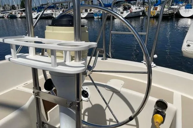 Slide: The Image of 1982 O'Day 28 sailboat helm with stainless steel wheel in marina setting. - 15