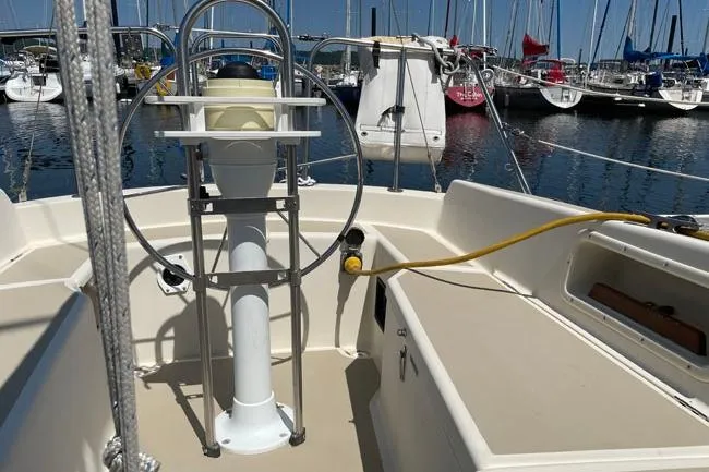 Slide: The Image of 1982 O'Day 28 sailboat cockpit with steering wheel, docked in marina. - 16