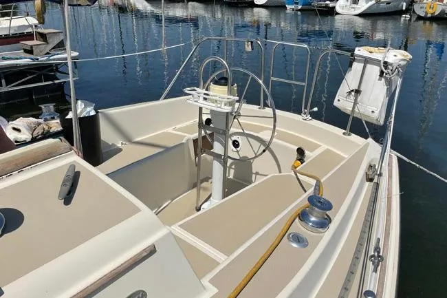 Slide: The Image of 1982 O'Day 28 sailboat cockpit with steering wheel, docked in marina. - 17