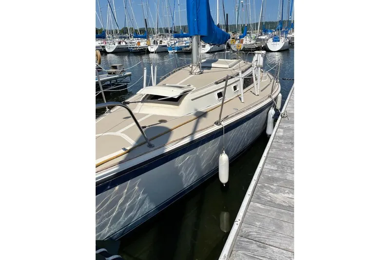 Slide: The Image of 1982 O'Day 28 sailboat docked in a marina with blue sail cover. - 18