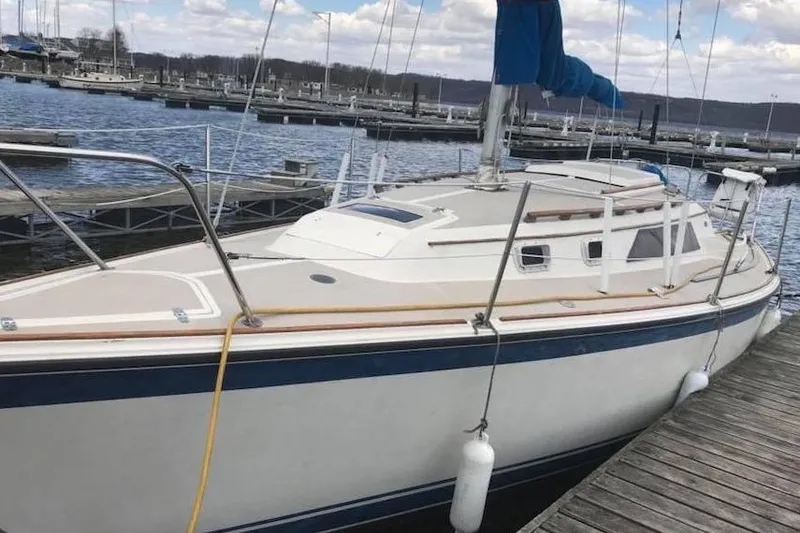 Slide: The Image of 1982 O'Day 28 sailboat docked at a marina, featuring a blue and white hull. - 19