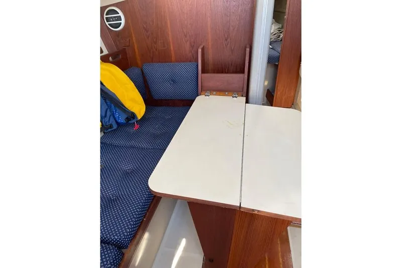 Slide: The Image of Interior of 1982 O'Day 28 sailboat with foldable table and cushioned seating. - 6