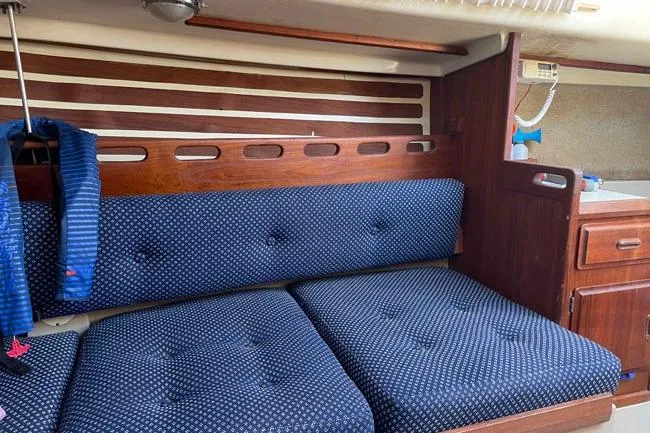 Slide: The Image of Interior of 1982 O'Day 28 sailboat with blue cushioned seating and wooden cabinetry. - 8