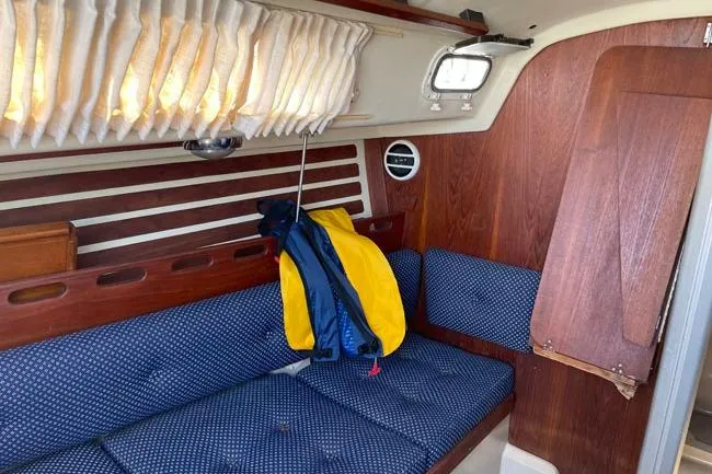 Slide: The Image of Interior of a 1982 O'Day 28 sailboat with blue seating and wooden accents. - 9