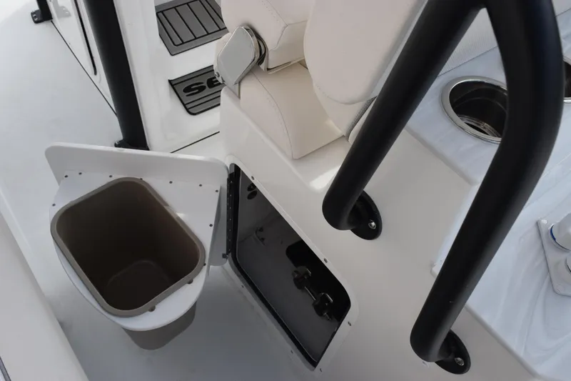 Slide: The Image of 2026 Sea Hunt Ultra 245 SE boat interior with storage compartment and cup holder. - 17