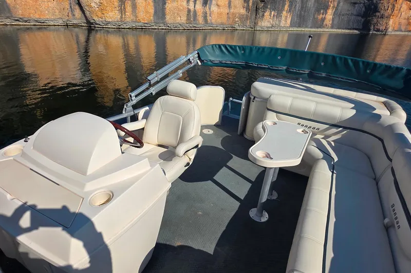 Slide: The Image of 2004 Sanpan 2500 RE pontoon boat with beige seating, docked on a calm lake. - 13
