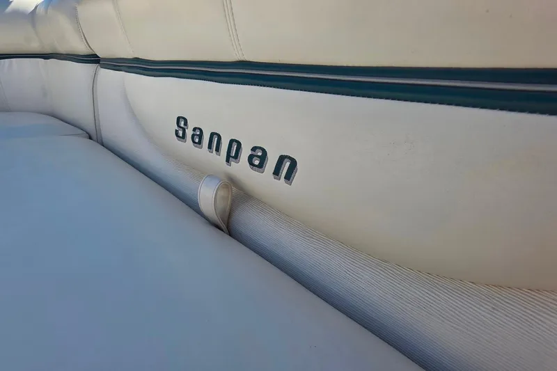 Slide: The Image of 2004 Sanpan 2500 RE pontoon boat with beige seating on calm water. - 15