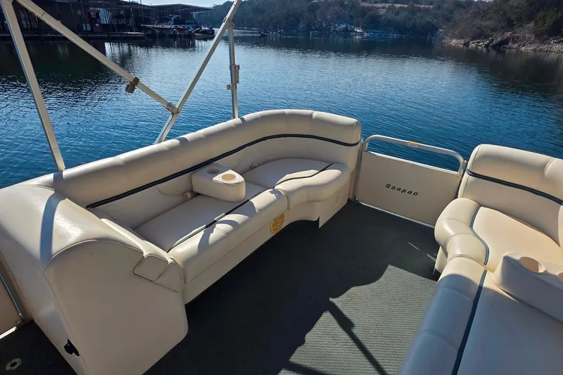 Slide: The Image of 2004 Sanpan 2500 RE pontoon boat with beige seating on calm water. - 18